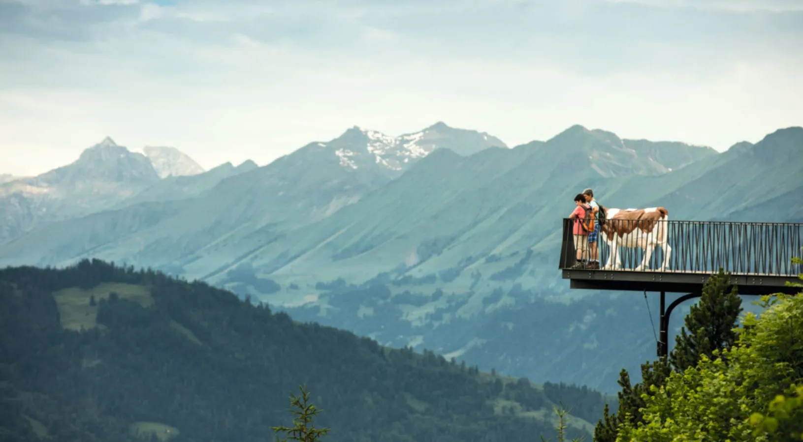 Two kids and a cow at the Viewing Platform of Harder Kulm.