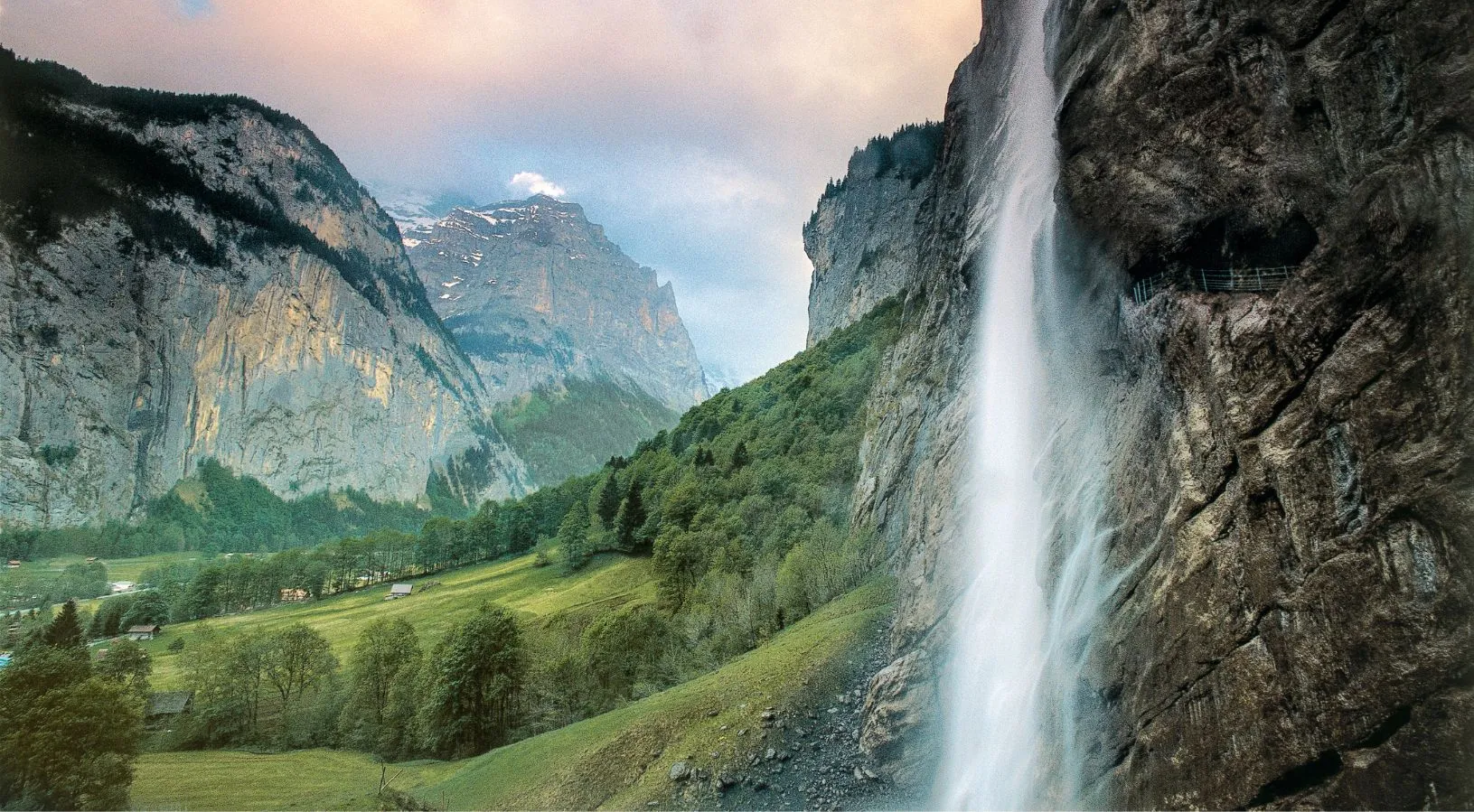 Lauterbrunnen Valley waterfall surrounded by alpine cliffs, a must-visit destination in Switzerland Tour Packages