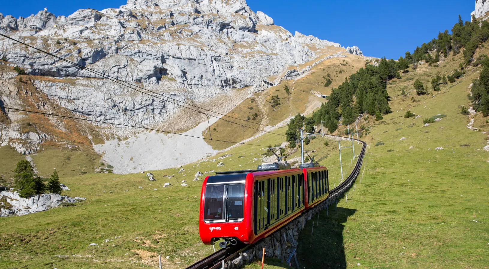 The red Pilatus cogwheel railway, the world's steepest at a 48 per cent gradient, climbing Mount Pilatus above Lake Lucerne near Lucerne, Switzerland